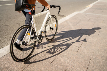 Fototapeta na wymiar Urban ecotransport. A cyclist goes to work with a briefcase.