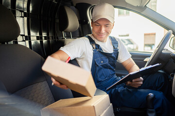 Courier delivery a male driver delivers orders in boxes to the house. Uniform and cap for an...