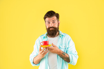 confused bearded guy hold morning coffee on yellow background, morning
