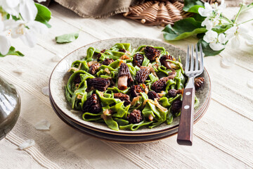 Homemade green nettle pasta with fried spring morel mushrooms