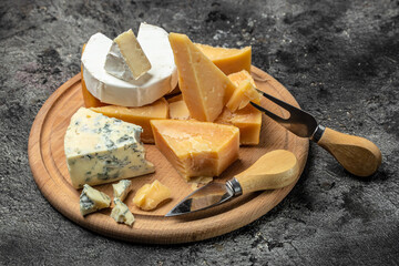 set of hard and soft cheeses parmesan, dor blu chedar camamber brie. Different types of cheese on a wooden background. place for text, top view