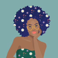 Beautiful black girl with fluffy hair and flowers in hair and dress