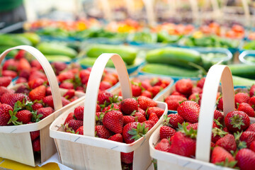 Strawberries for sale on vegetables market. Raw juicy strawberry in wooden basket standing on...
