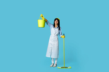 woman in rubber gloves and cleaner apron with cleaning supplies