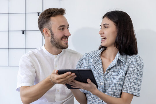 Couple using tablet buying online at home. Woman and Man using tablet for video call to friend.