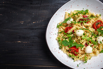 Caprese salad Pasta with tomato, mozzarella vegetable on a dark background, Restaurant menu,...