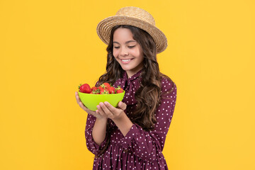 happy teen kid hold strawberry bowl on yellow background