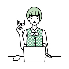 デスクで座ってPCを使いながらクレジットカードを手に持っている事務員制服の女性