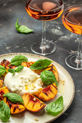 Burrata cheese and grilled peaches with rose wine, vertical image. top view. place for text