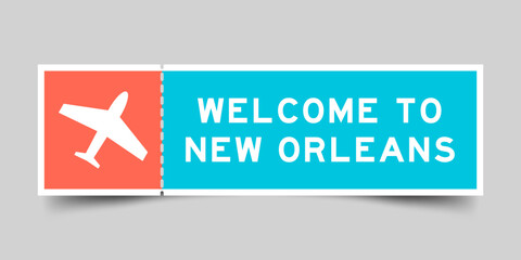Orange and blue color ticket with plane icon and word welcome to new orleans on gray background