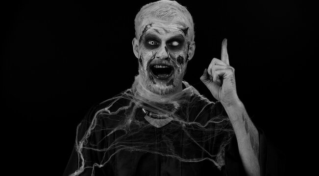 Eureka. Inspired sinister man Halloween crazy zombie with bloody wounded scars face make gesture raises finger came up with creative plan feels excited with good idea, inspiration motivation. Horror