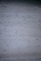 background of a light gray iron shiny sheet of iron, after the rain with dew drops, after the rain, the texture of water drops on a steel sheet with a shadow