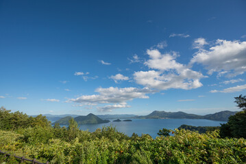 サイロ展望台から青い空と洞爺湖、昭和新山、有珠山の眺望