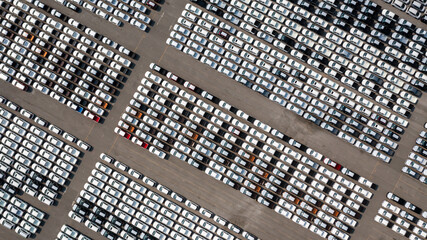 Aerial top view parked new cars at the automotive plant, new car lined up in the port for import...