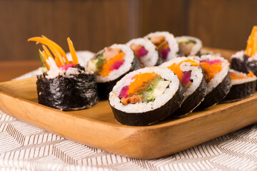 Korean gimbap or kimbap that has been cut and served on a wooden plate