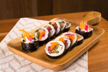 Korean gimbap or kimbap that has been cut and served on a wooden plate