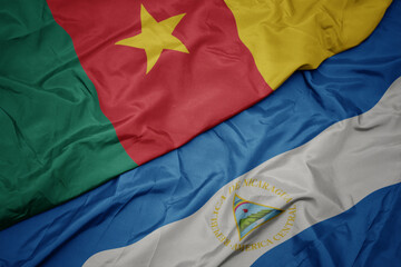 waving colorful flag of cameroon and national flag of nicaragua. 3d illustration