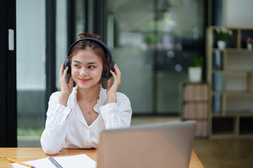 woman using a computer and earphone during a video conference