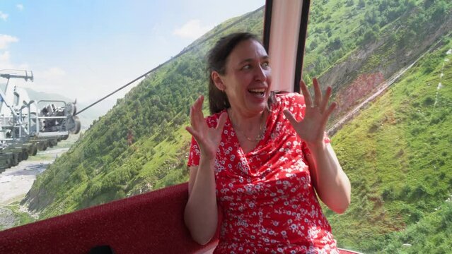 Travel in Georgia. A beautiful woman sitting in a cable car was afraid of heights.