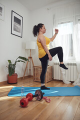 Fototapeta na wymiar Woman training inside the living room, exercising at home.