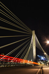 Fototapeta na wymiar Puente de los tirantes sobre el Río Lerez en Pontevedra, Estela roja de un coche pasando.
