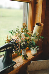 wedding beautiful bouquet with different flowers roses greenery indoors sewing machine decor