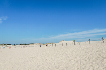 Rippled sand background, dune and see in Slowinski National Park, Leba, Poland. Beautiful scenery of sand dunes and ocean.