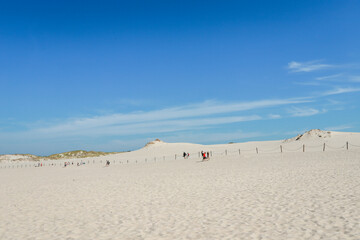 Rippled sand background, dune and see in Slowinski National Park, Leba, Poland. Beautiful scenery of sand dunes and ocean.