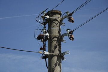 Head of concrete power pole and with wires and isolators, blue spring sky, concept: supply, electricity (horizontal), Wolfstein, RLP, Germany