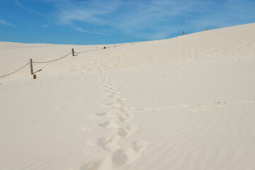 Rippled sand background, dune and see in Slowinski National Park, Leba, Poland. Beautiful scenery of sand dunes and ocean.