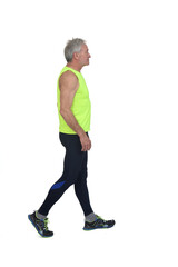 Side view of a senior man with sportswear walking on white background