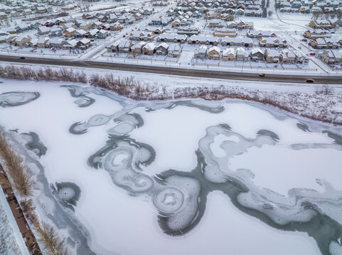 frozen pond and residential area in winter scenery after sunset, aerial view of Fort Collins area in northern Colorado