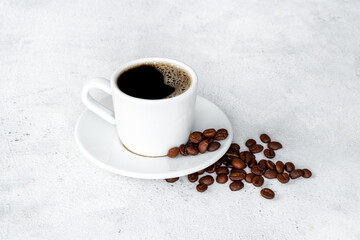 Black coffee - espresso - in white cup with coffee beans
