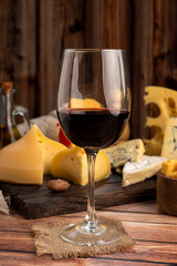 Red wine cup with varieties of oil and pepper background cheese and red wine bottle