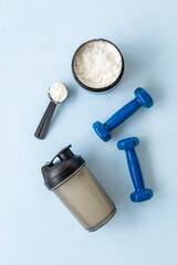Sport bottle and jar of powder whey protein and dumbbells. Fitness and gym diet