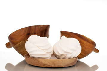 Two sweet white marshmallows on a wooden saucer with two cups, macro, isolated on white background.