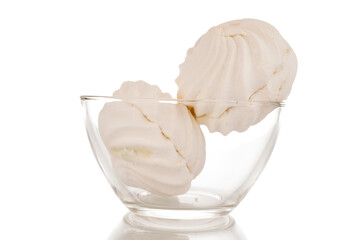 Two sweet white marshmallows in a glass bowl, macro, isolated on white background.