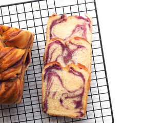 top view sliced braided babka brioche with purple sweet potato filling on white background