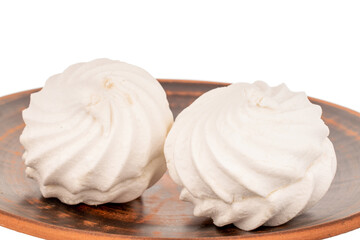 Two sweet white marshmallows on earthenware, macro, isolated on white background.