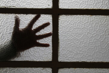 Ventana o mampara de vidrio con silueta de una mano abierta en el vèrtice con divisiones de hierro negro, forma un original y ùnico diseño abstracto con fondo de los vidrios texturizados 