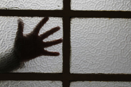 Ventana o mampara de vidrio con silueta de una mano abierta en el v&egrave;rtice con divisiones de hierro negro, forma un original y &ugrave;nico dise&ntilde;o abstracto con fondo de los vidrios texturizados 