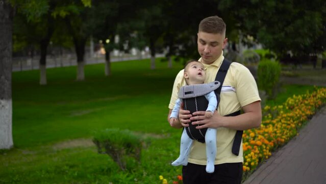 A young father walks with a child in the park. 