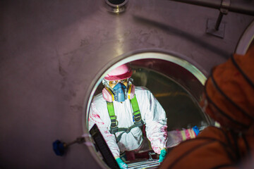 Top view male climbs up the stairs into the tank stainless chemical area confined space safety