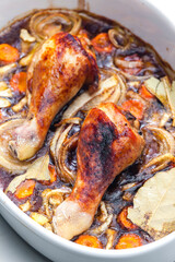 chicken legs baked with onion, carrot and bay leaves