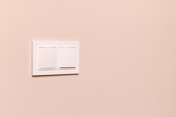 Group of white electrical switches on modern beige wall