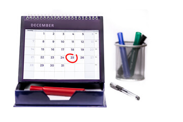 Red circle round date of 25th December (Christmas Day) on a business desk diary isolated on a white background