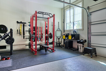Fototapeta na wymiar Home Gym for Weightlifting with free weights in Garage with lots of equipment