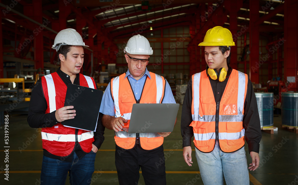 Poster a manager using an empty laptop schematically with a team of multi-ethnic male engineers in safety c