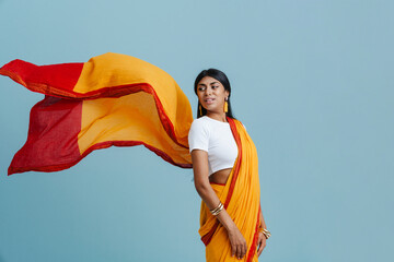 Young beautiful indian woman in flying sari looking backward