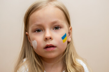 little Ukrainian woman with a picture of the flag of Ukraine and the heart of peace